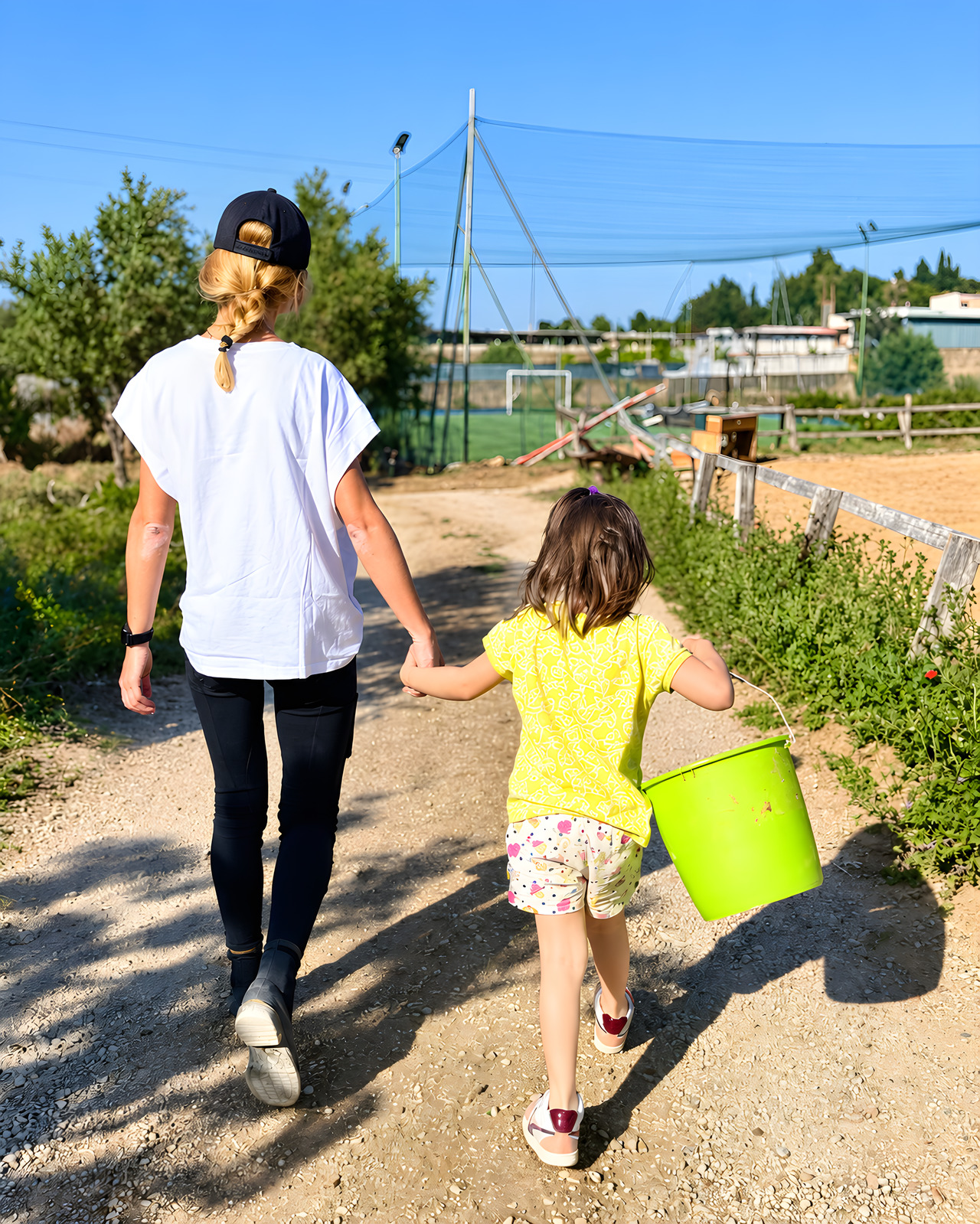 Una donna e una bambina risalgono il sentiero con il secchio